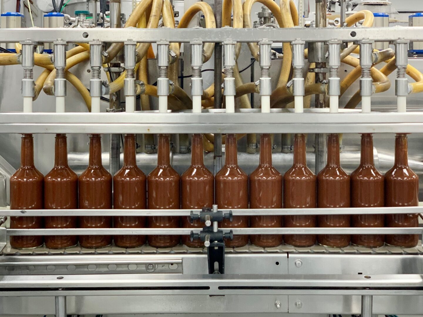 Chocolate liquid being packed in bottles by a machine